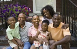 Image of a multi-generational African American family sitting on a front step of a home